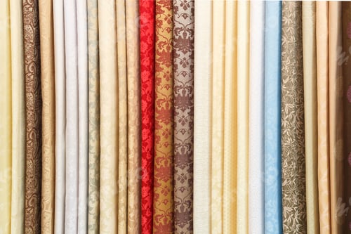 Preview: wide selection of different color textile silk fabrics clothes lay in row in drapery store