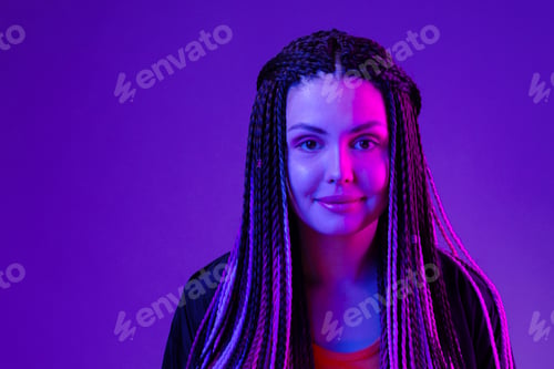 Preview: Fashion portrait of young woman with dreadlocks in neon light