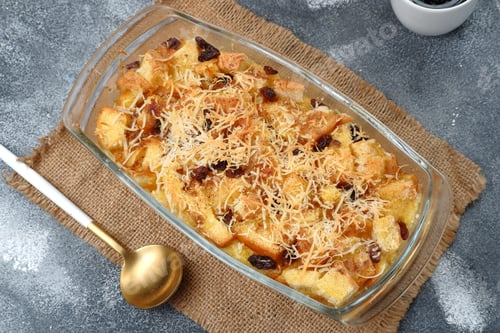 Preview: Homemade bread butter pudding with raisins and grated cheese as topping
