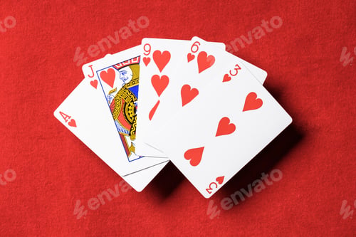 Preview: top view of red poker table and unfolded playing cards with hearts suit