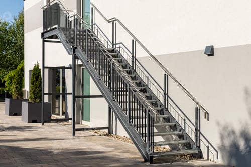 Preview: Sleek metal staircase connects the ground level to upper floor of contemporary building.