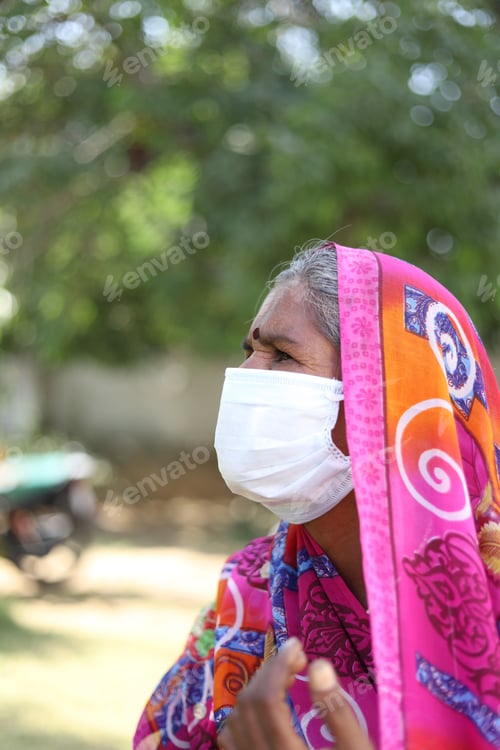 Preview: Vertical shot of an Indian woman with a traditional dress and white mask