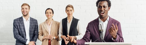 Preview: panoramic shot of african american businessman in formal wear talking during conference