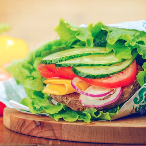 Preview: Fresh and colorful vegetable and cheese wrap prepared on a wooden cutting board in a cozy kitchen