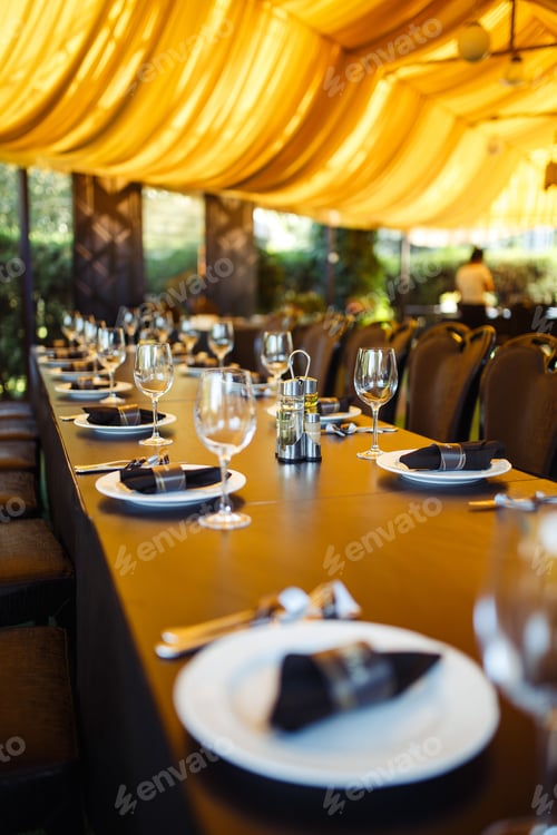 Preview: Sparkling glassware stands on long table prepared for wedding dinner.