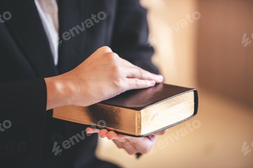 Preview: focus on woman's hand While praying for Christianity with blurry body background, casual woman prays