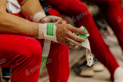 Preview: hand male gymnast in grips and gym chalk exercise on horizontal bar competition artistic gymnastics