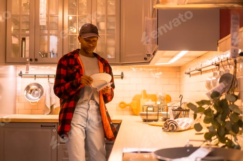 Preview: Black ethnic man shopping in a furniture store, looking at kitchen cabinets