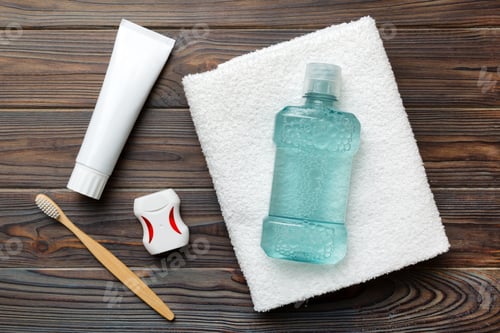 Preview: Mouthwash and other oral hygiene products on colored table top view with copy space.
