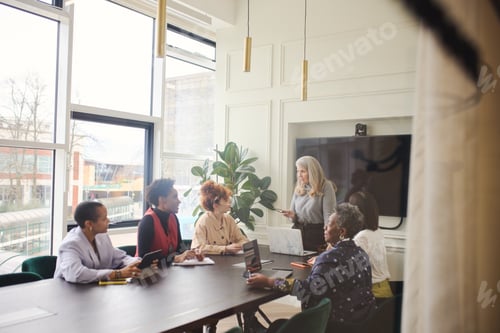 Preview: Portrait of senior white businesswoman discussing with multiethnic female colleagues