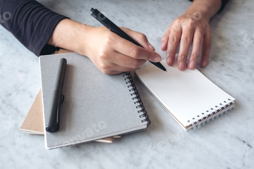 Preview: Closeup image of hands writing on blank notebook on the table