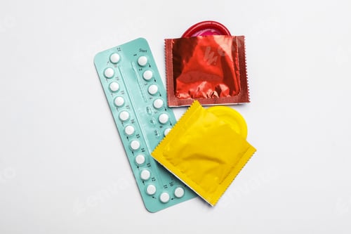 Preview: Condoms and birth control pills on white background, top view. Safe sex concept