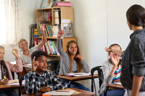 Preview: Shot of a group of schoolchildren raising their hands to answer their teachers question in class