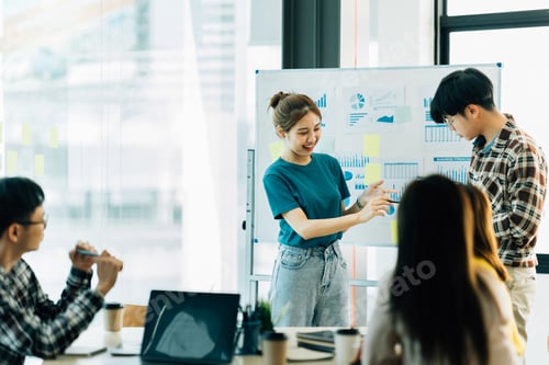 Preview: group of four happy young asian corporate people teammates meeting discussing business in office.