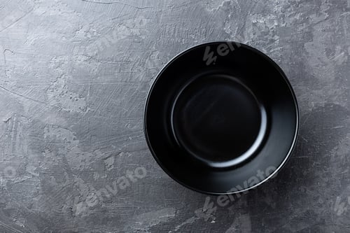Preview: Empty black soup plate on dark grey background, top view