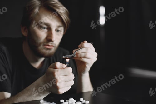 Preview: Addict preparing drug dose for injection in dark room