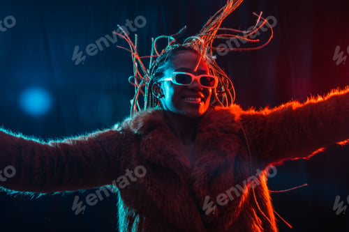 Preview: Black ethnic woman with braids with blue and red led lights, moving her hair while dancing