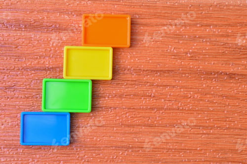 Preview: Colorful plastic blocks isolated on a wooden background
