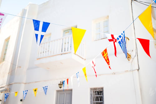 Preview: Street with colorful flags in Mykonos, Greece