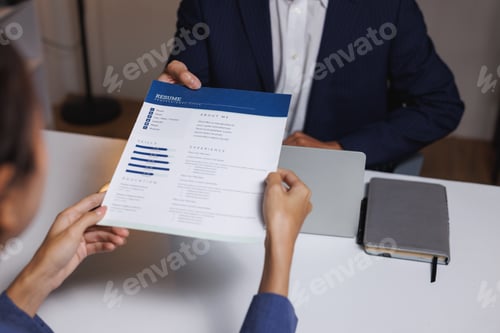 Preview: Applicant giving resume to recruiter during job interview