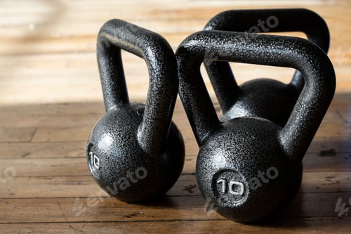 Preview: Set of black kettlebells on wooden floor