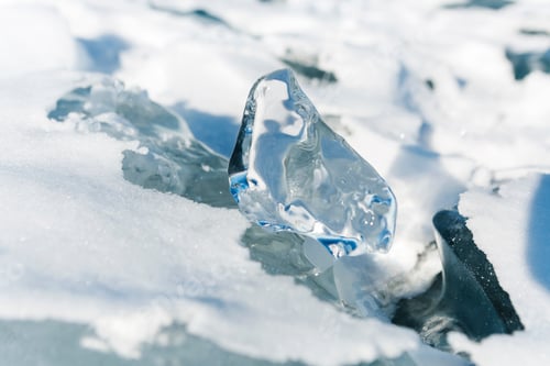 Preview: Pieces of ice lying on the ideal smooth ice of baikal with ice hummocks in the horizon