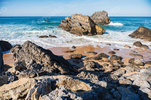 Preview: Portugal sandy beach with rocky coastline and ocean waves