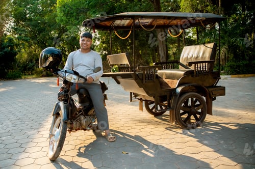 Preview: Smiling man sitting on a traditional motorized rickshaw