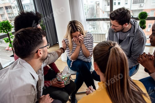 Preview: Diverse group of people sitting in circle in group therapy session.
