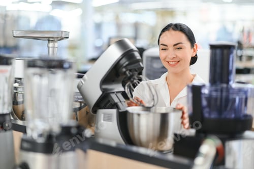 Preview: Young woman choosing kitchen mixer blender in home appliance shopping mall supermarket