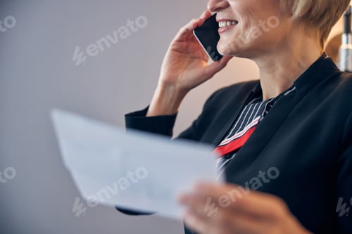Preview: Cheerful woman having phone conversation and smiling