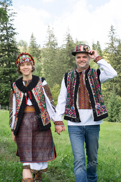 Preview: Young couple in traditional ukrainian clothes in the Carpathian mountains near the house full of lov