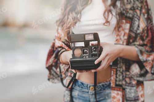 Preview: Lady with camera on shore near stones and water