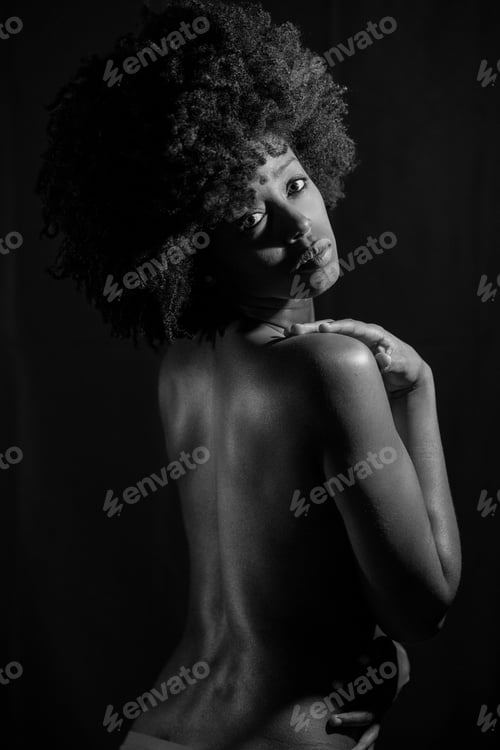 Preview: Black and white photograph of naked black woman under neon light