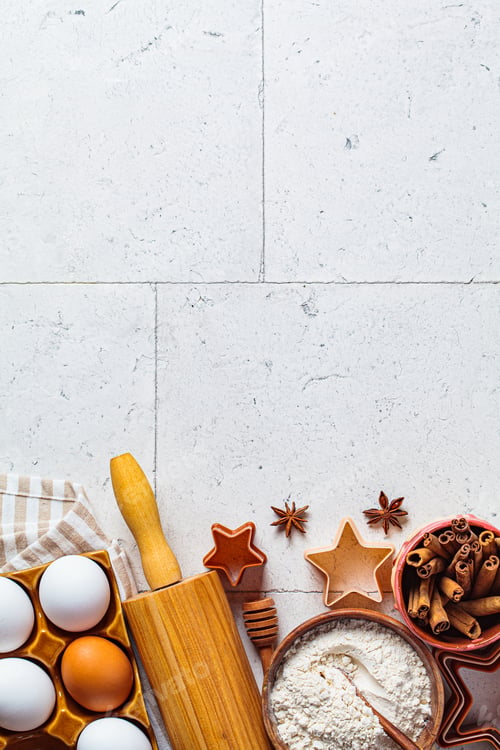 Preview: Christmas baking concept. Ingredients for christmas cookies on gray tiles background, copy space.