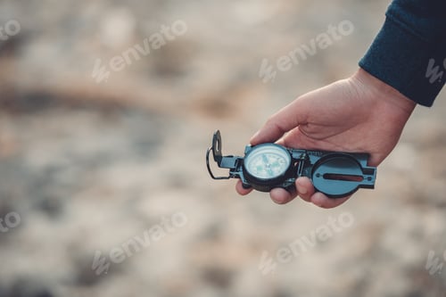 Preview: close-up partial view of man holding compass while hiking