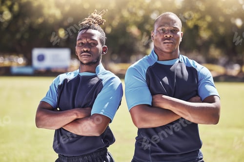 Preview: Portrait two young african american rugby players standing with their arms crossed outside on the f