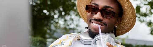 Preview: Digital nomad enjoying a refreshing drink while working outdoors in a vibrant setting