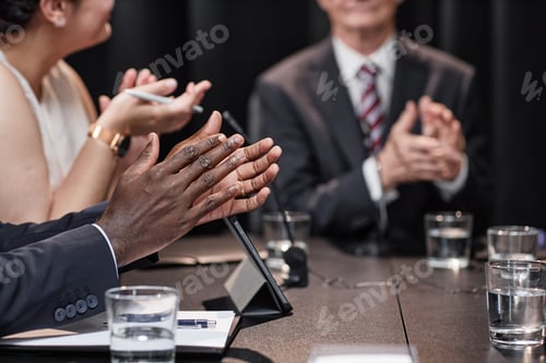 Preview: Male Politician Clapping Hands in Support of Speaker at Conference Table Indoors