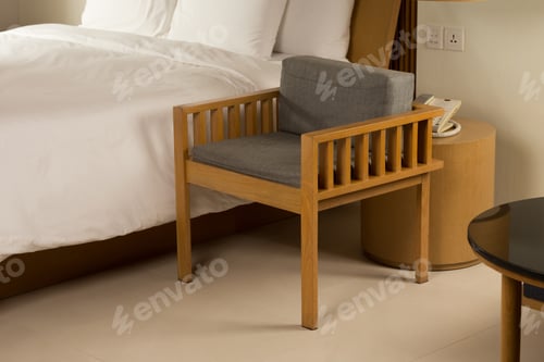Preview: An elegant bedroom, featuring a wooden chair and a cozy bed, bathed in warm, inviting light.