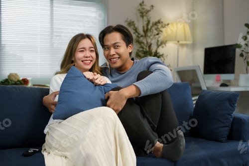 Preview: Happy couple relaxing on a cozy sofa at home