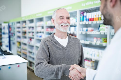 Preview: Pharmacist and customer shaking hands in pharmacy
