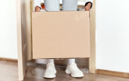 Preview: Unrecognizable African American Lady Taking Delivered Box From Floor Indoor