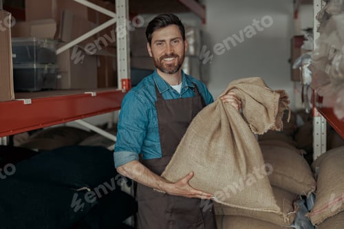 Preview: Portrait of baristas in uniform standing with bag full of coffee beans at coffee store