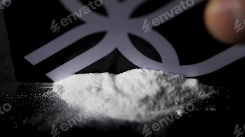 Preview: DRUGS: Man does a lines of heroin by plastic card - Close up. Plastic card and white powder. Lines
