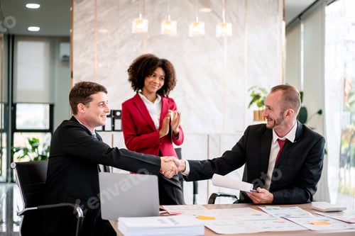 Preview: Three people in suits shaking hands in a conference room