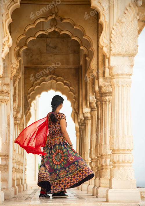 Preview: Young female tourist dancing between arches and Pillars.