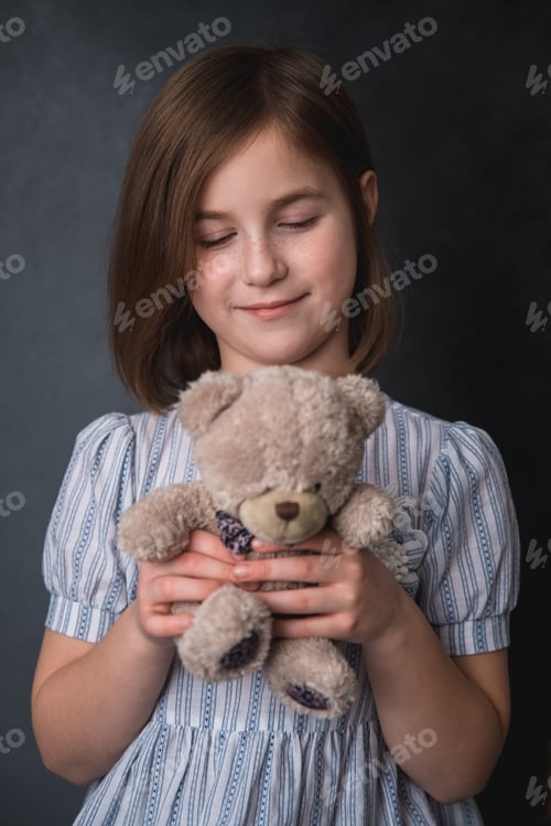 Preview: portrait of a cute little girl with freckles in a dress with teddy bear