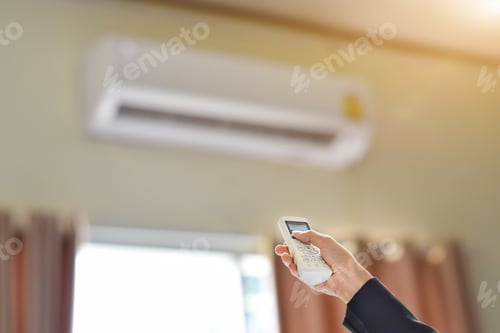 Preview: Close up of businessman hand holding remote control directed adjusting of air conditioner.