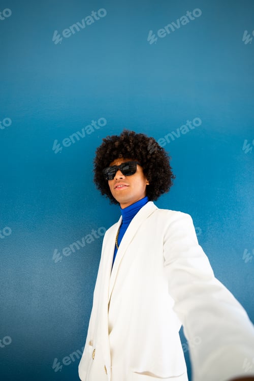 Preview: Young afro mexican man taking a vertical selfie